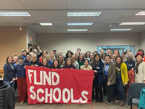Group of parents and community members attending Lobby Day with big red sign "FUND SCHOOLS"
